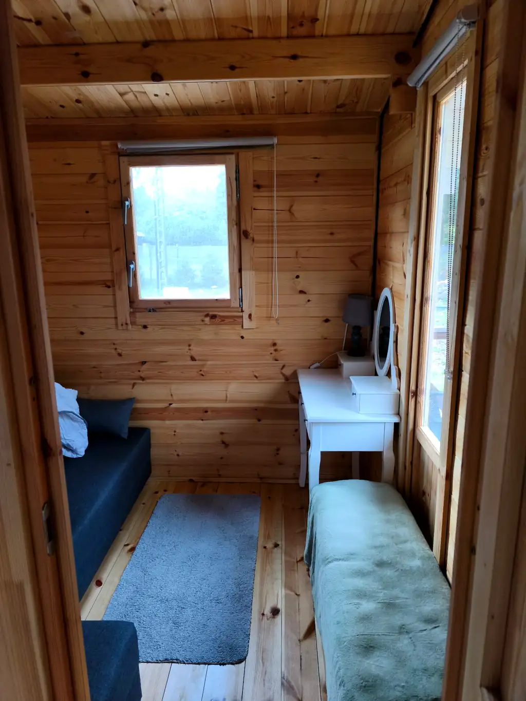 Bedroom in cottage no. 3: two single sleeping places and a white dressing table with a round mirror